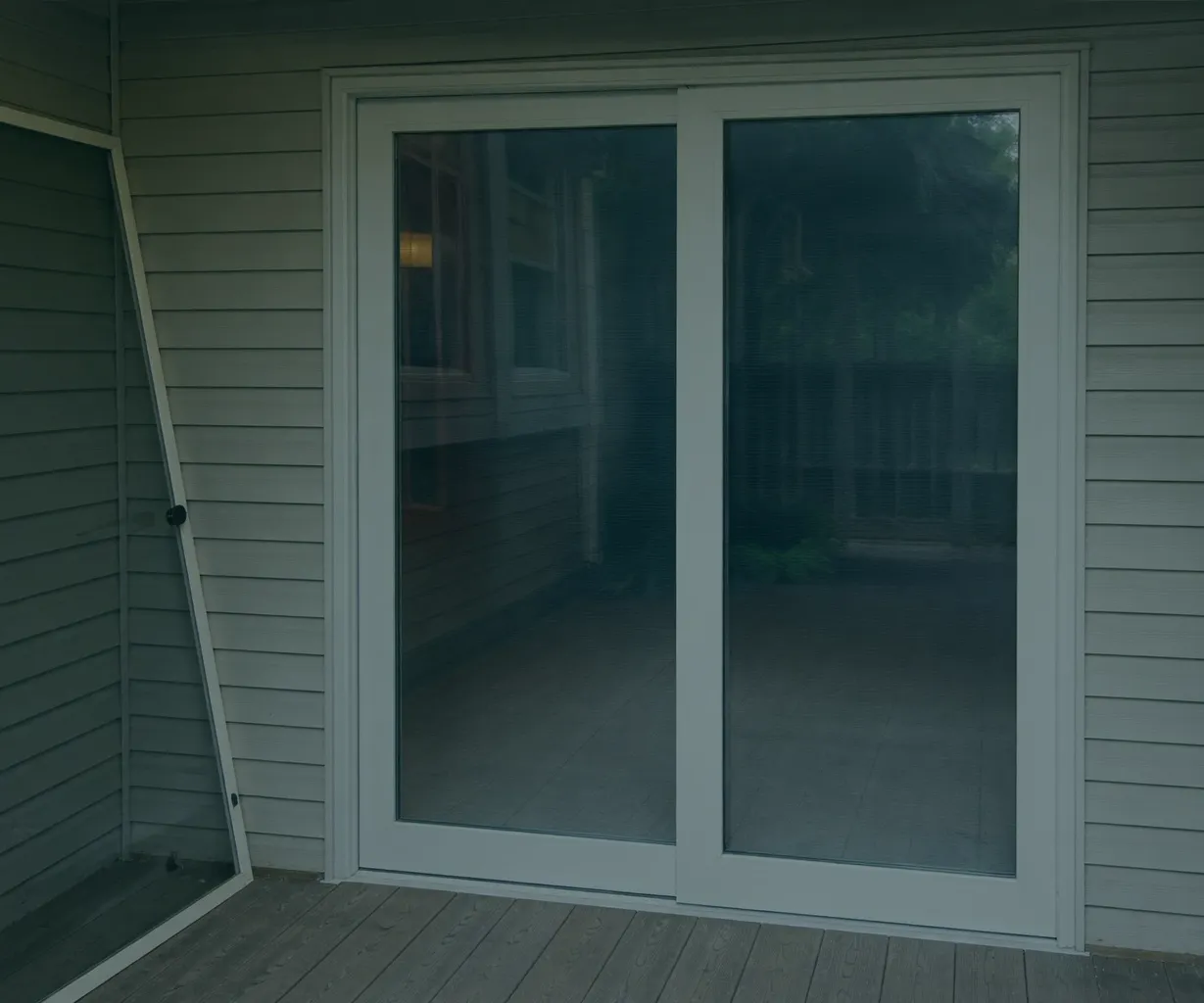 Sliding door repair technician working on a contemporary aluminum glass door